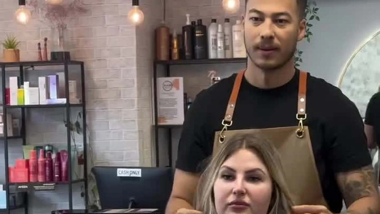 Hairstylist finishing a client's long blonde hair at the colour bar on Capel Street, Dublin