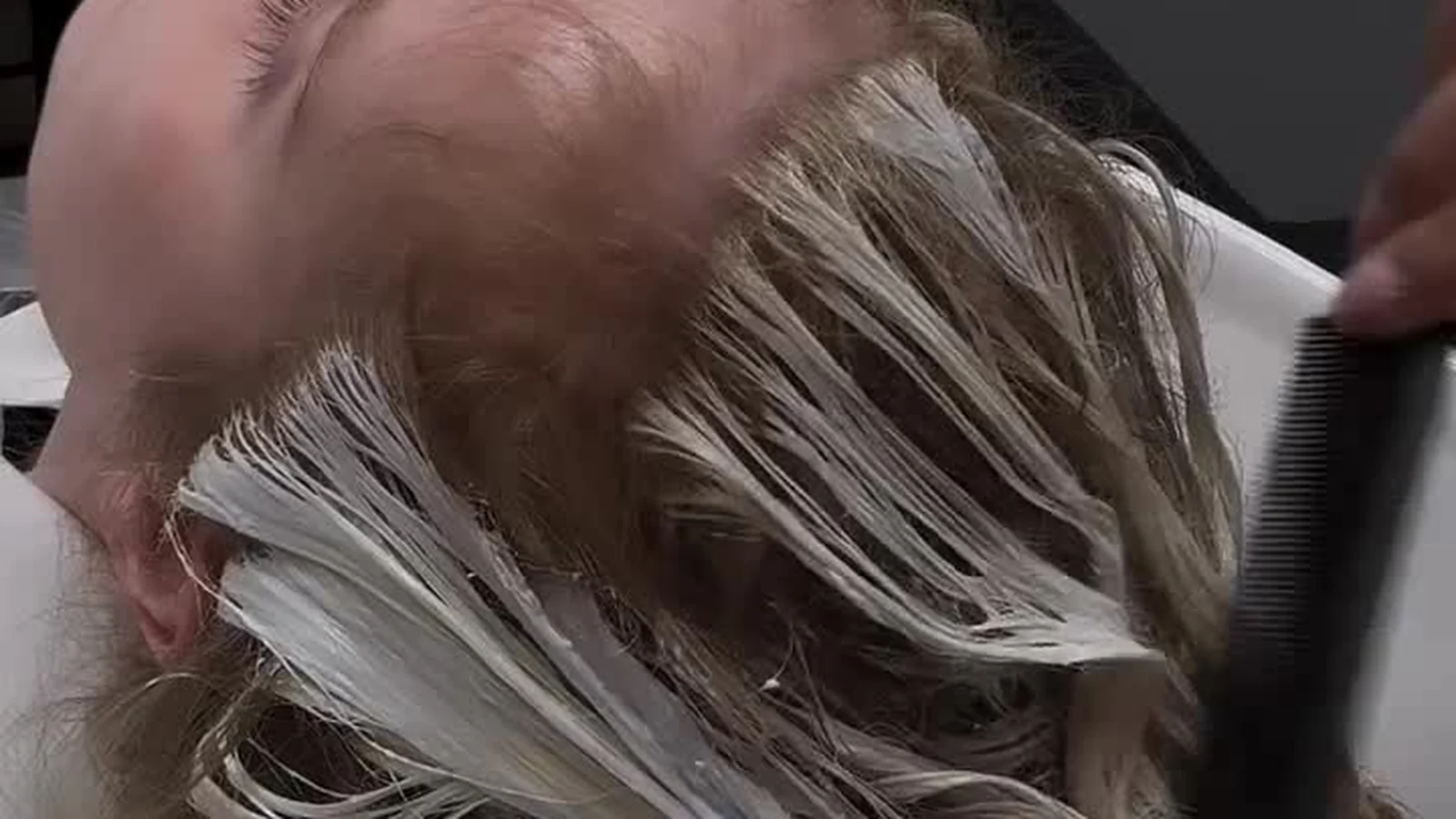 Colourist combing balayage lightener through sectioned hair at the Capel Street colour bar in Dublin